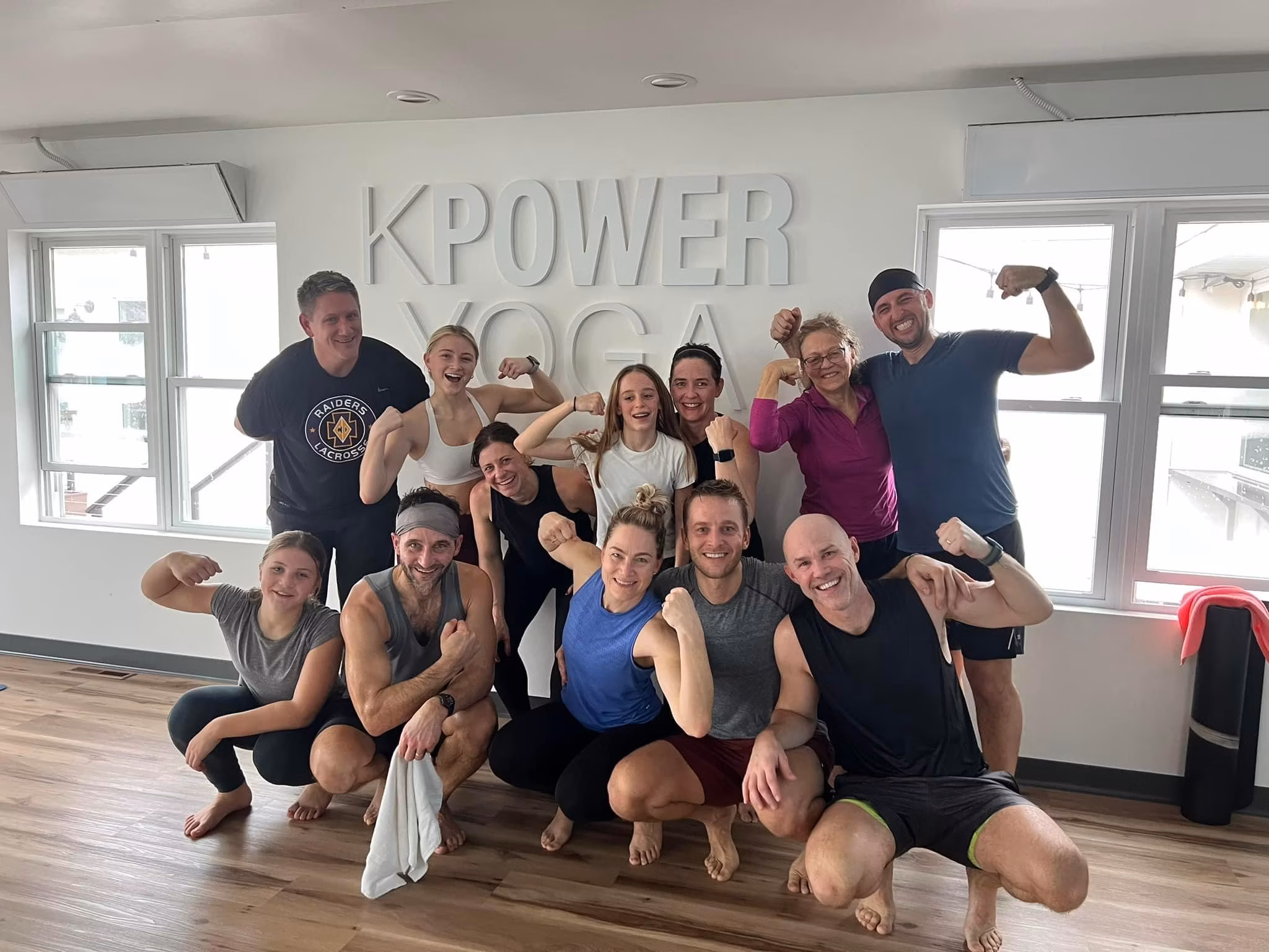 Post-class group flexing and laughing in the bright St. Joseph studio