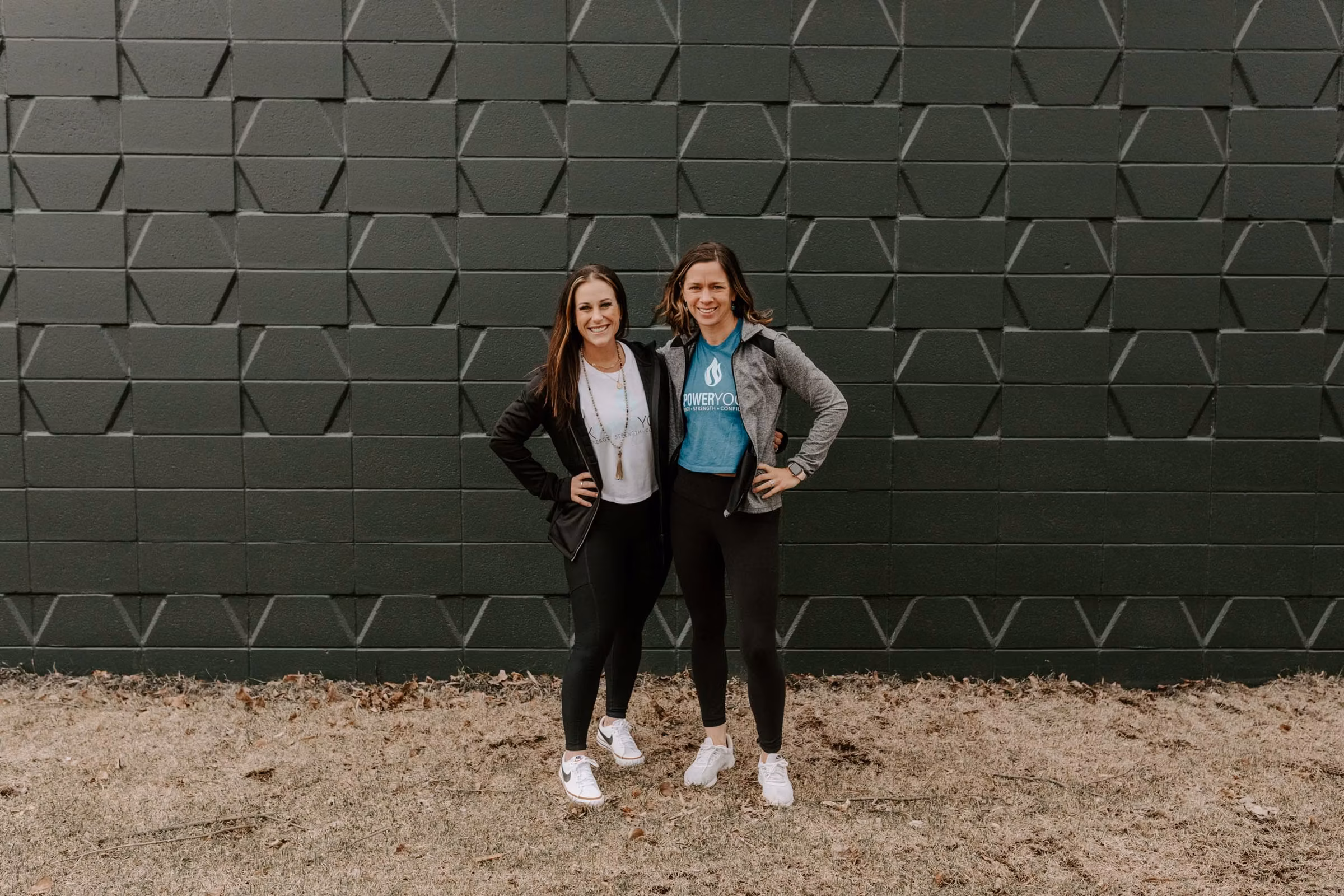 Co-owners Kelsey and Meghann smiling in K.Power gear