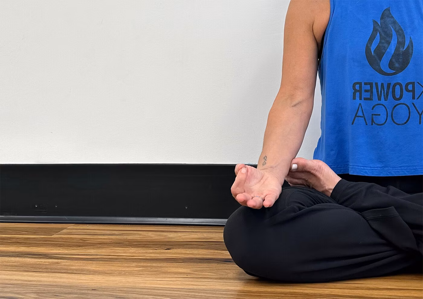 Close-up of a seated meditation with an upturned palm in a K.Power tank